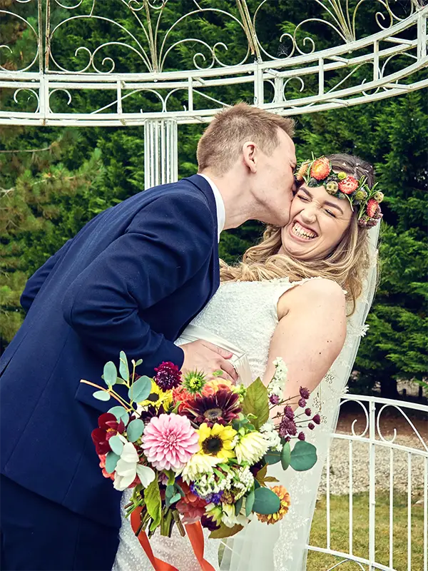 Groom kissing bride on cheek after their wedding in Worcester Groom kissing bride on cheek after their wedding in Worcester