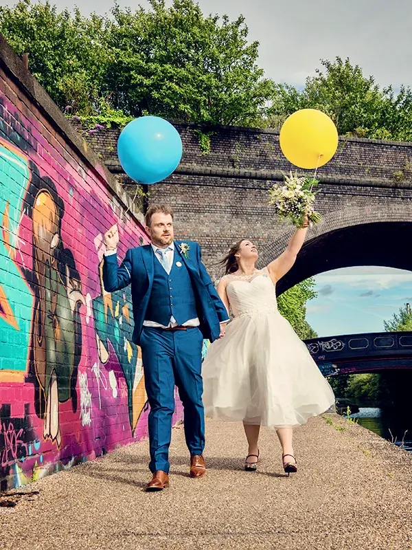 Newlyweds holding balloons walking along Worcester canal Newlyweds holding balloons walking along Worcester canal