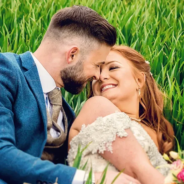 Groom and bride laying down in a field surrounded by tall grass in Worcester Groom and bride laying down in a field surrounded by tall grass in Worcester