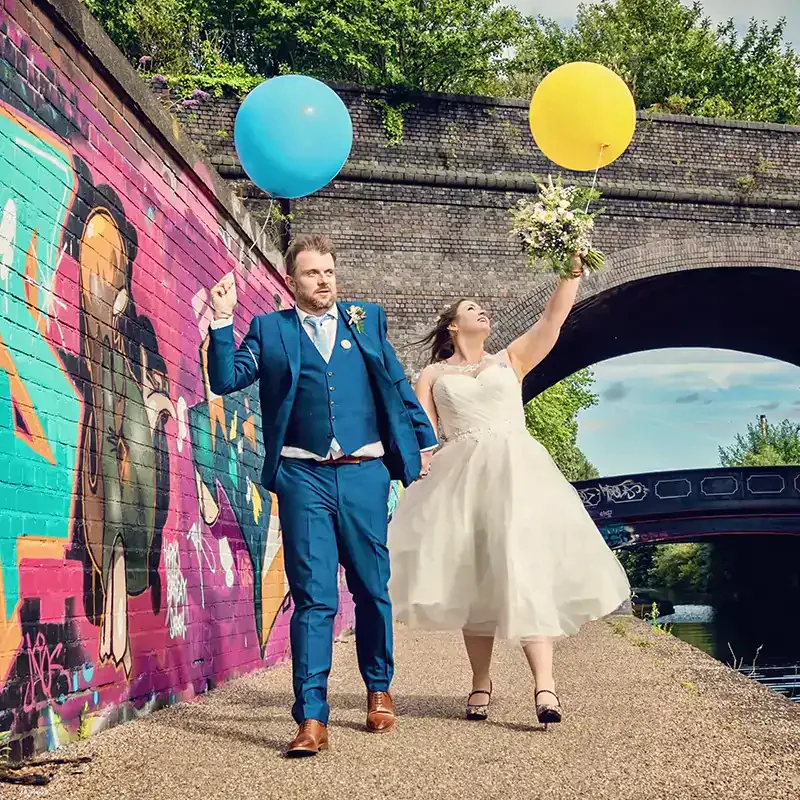 Newlyweds holding balloons walking along Worcester canal Newlyweds holding balloons walking along Worcester canal